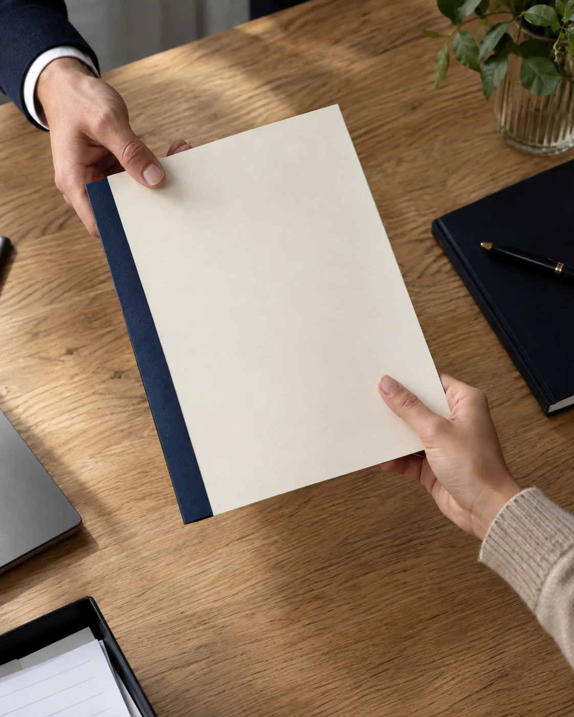 Twee mensen dragen een papieren dossier over aan tafel