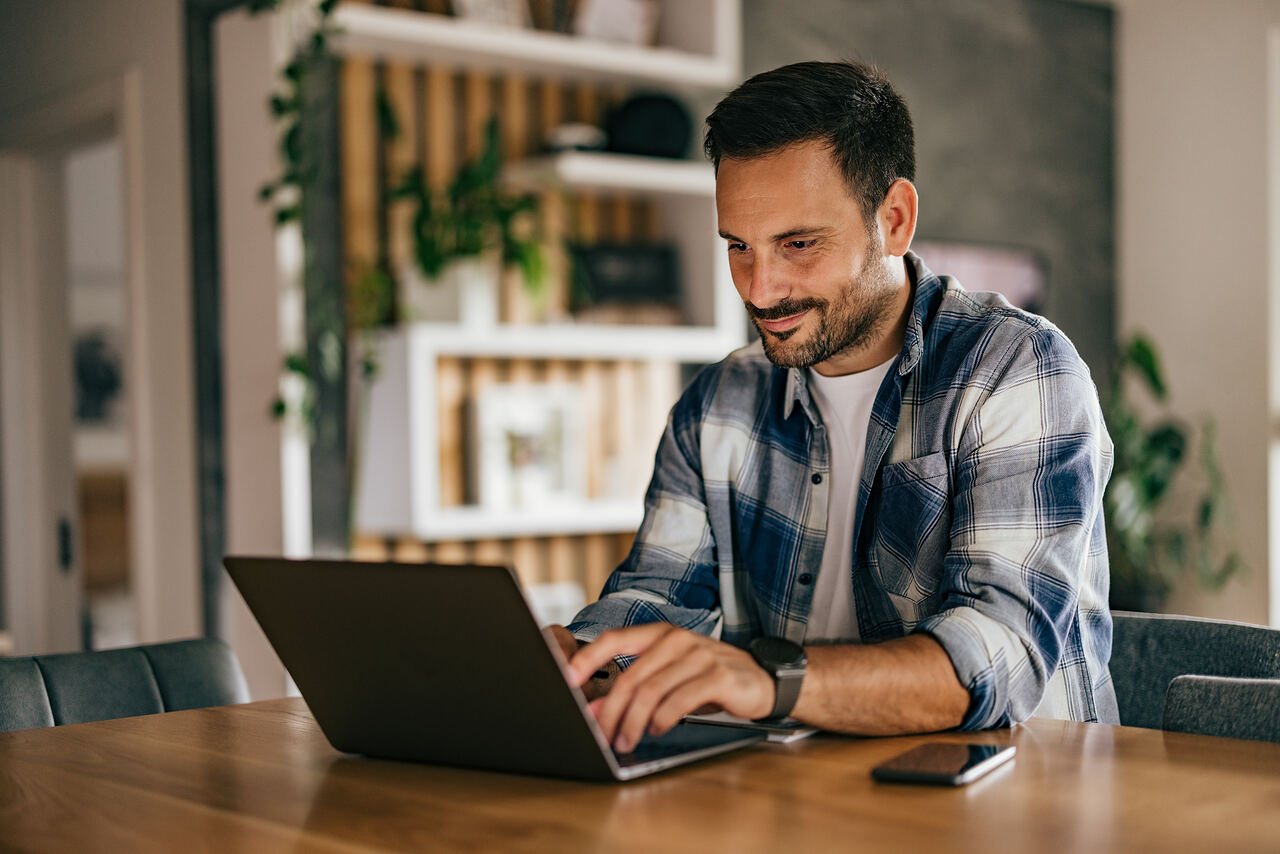Ondernemer werkt ontspannen aan tafel met laptop